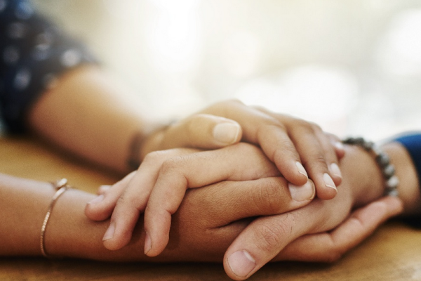 Bild: Ein Mensch hält die Hände eines anderen, Titelbild der Tagung, Quelle: zeppbremen.de